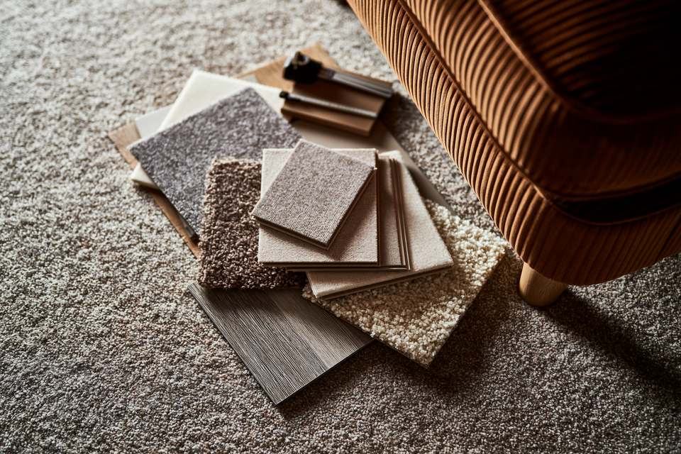 A selection of carpet and flooring samples gathered beside a chair while choosing flooring