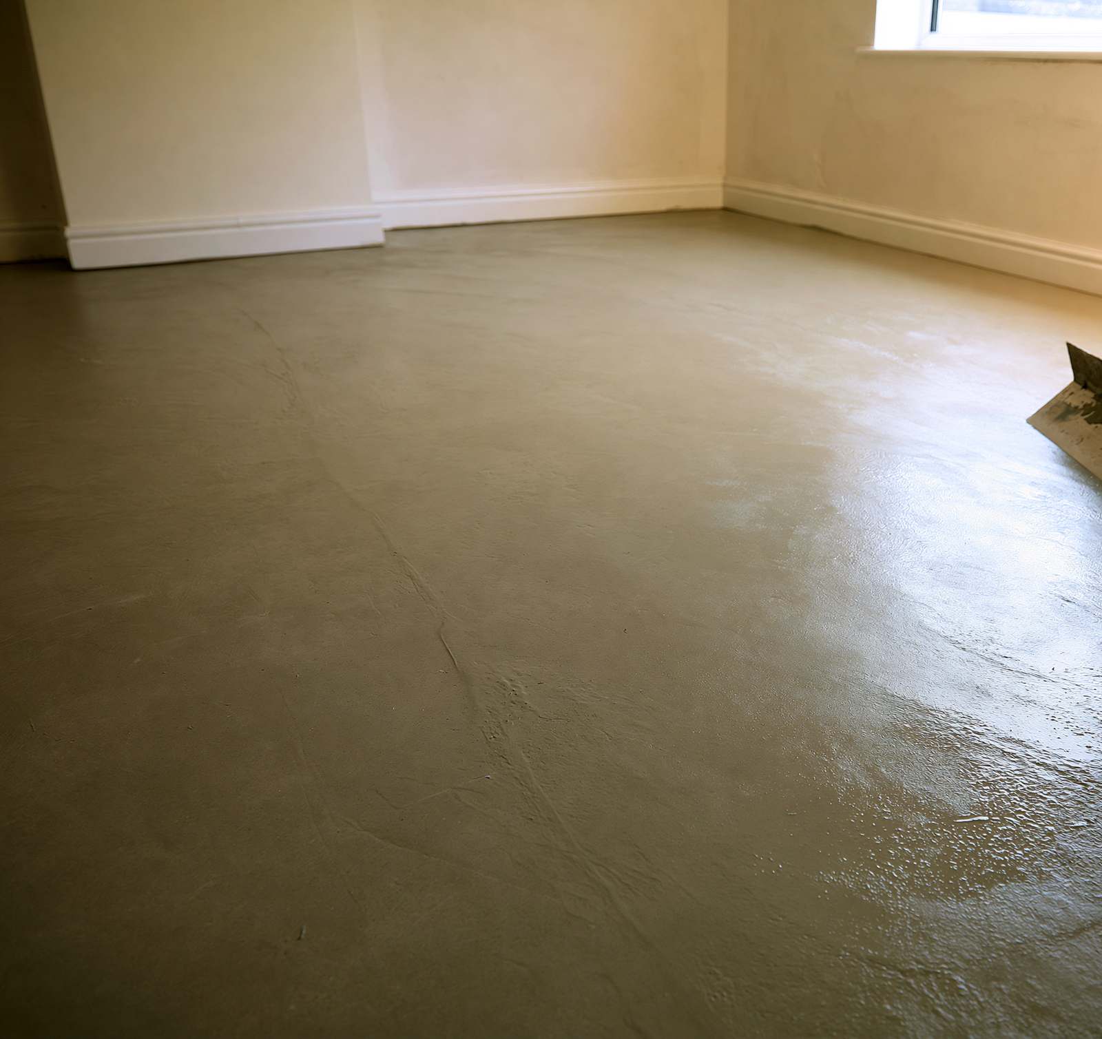 A smoothed, self-levelled subfloor being prepared before luxury vinyl tile is fitted